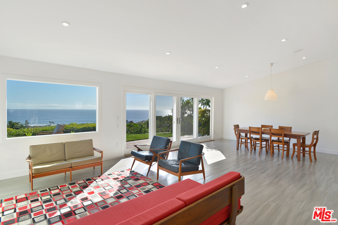 6249 Tapia Drive Malibu, CA 90265 - Photo 7 of 21 a living room with furniture and a dining table with wooden floor