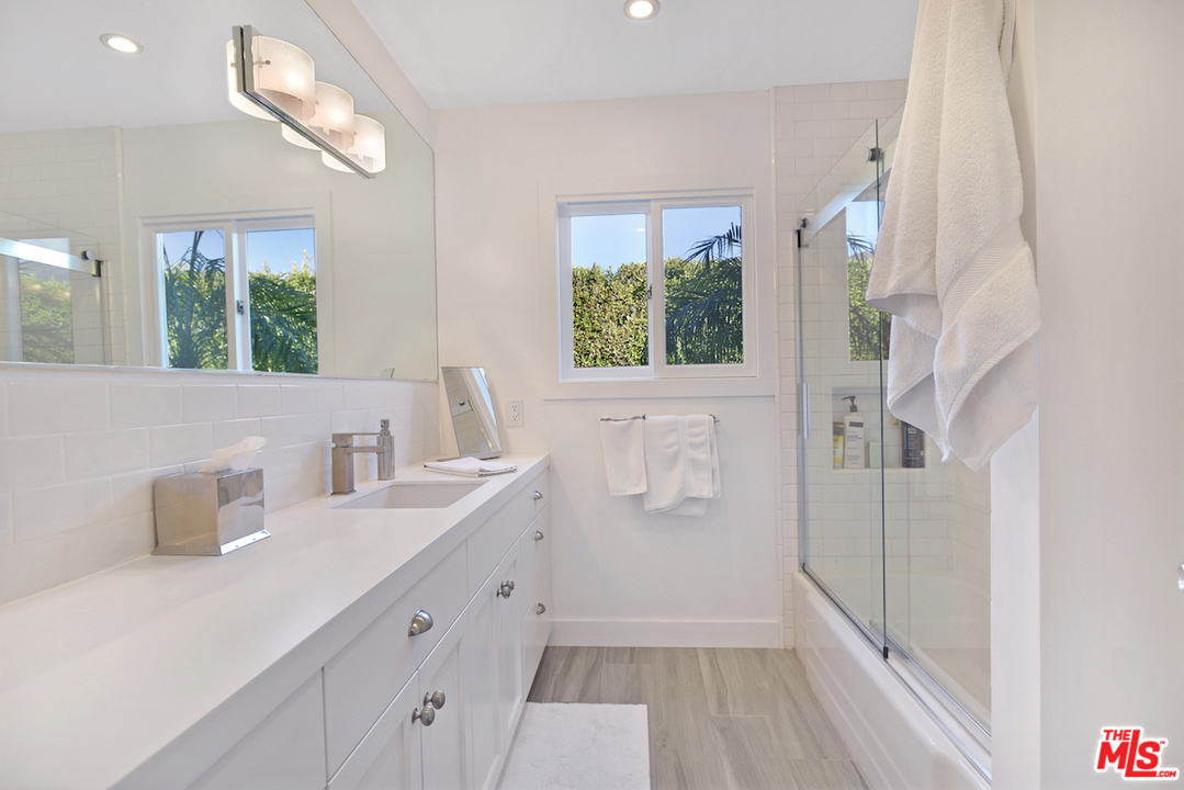6249 Tapia Drive Malibu, CA 90265 - Photo 10 of 21 a bathroom with a double vanity sink a mirror and a bathtub