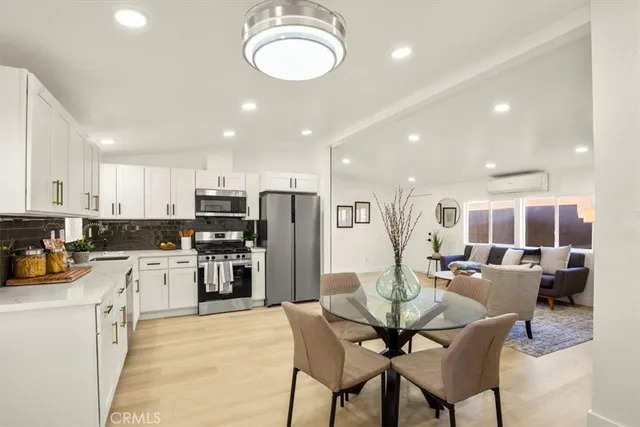a kitchen with white cabinets and stainless steel appliances