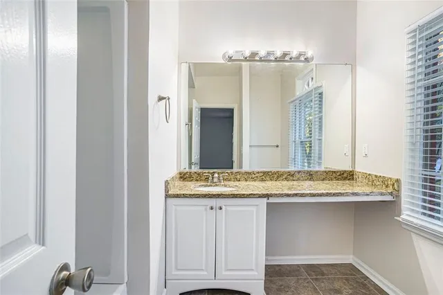a bathroom with a granite countertop sink and a mirror