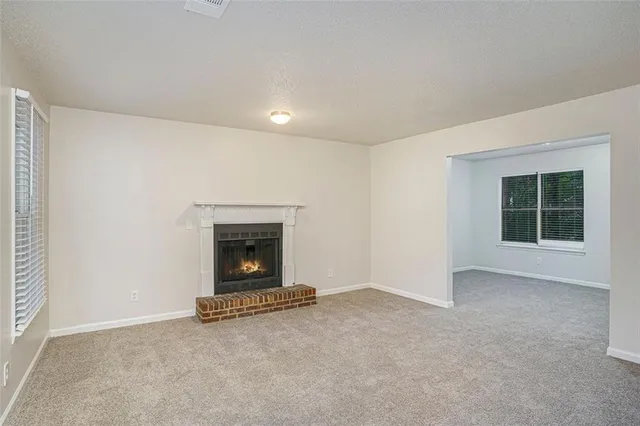 an empty room with a fireplace and window