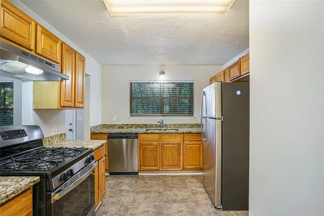 a kitchen with stainless steel appliances granite countertop a stove and a sink