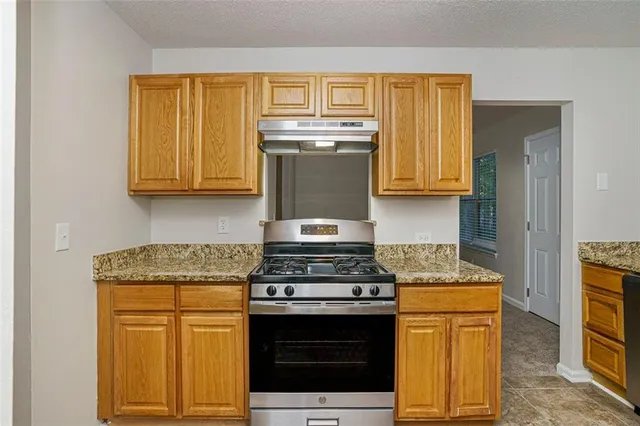 a kitchen with granite countertop cabinets stainless steel appliances and wooden cabinets