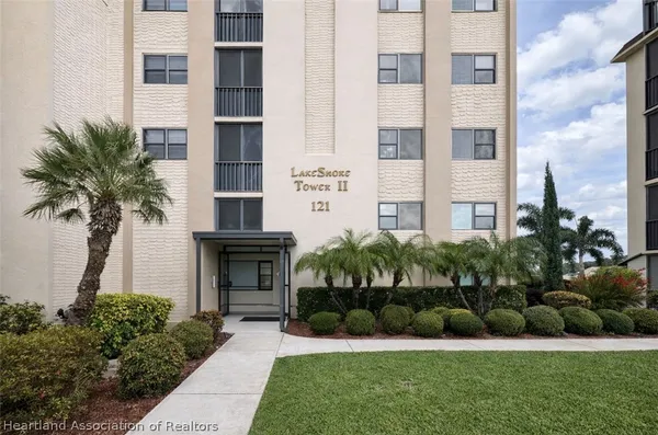 a front view of a multi story building with yard
