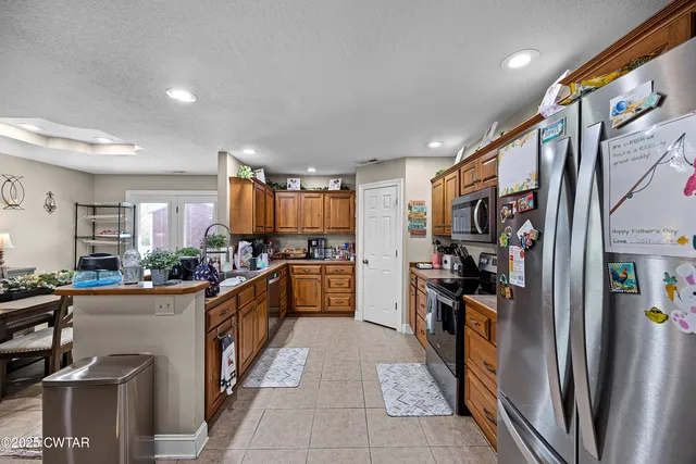 a kitchen with stainless steel appliances a refrigerator a sink a stove and a refrigerator