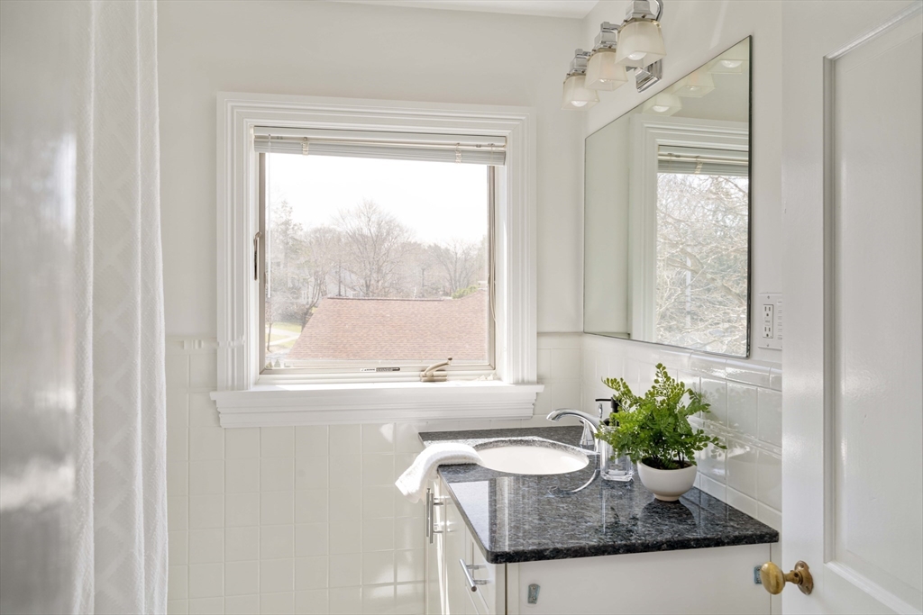 8 Littlefield Road Newton, MA 02459 - Photo 28 of 33 a bathroom with a granite countertop sink a mirror and a window