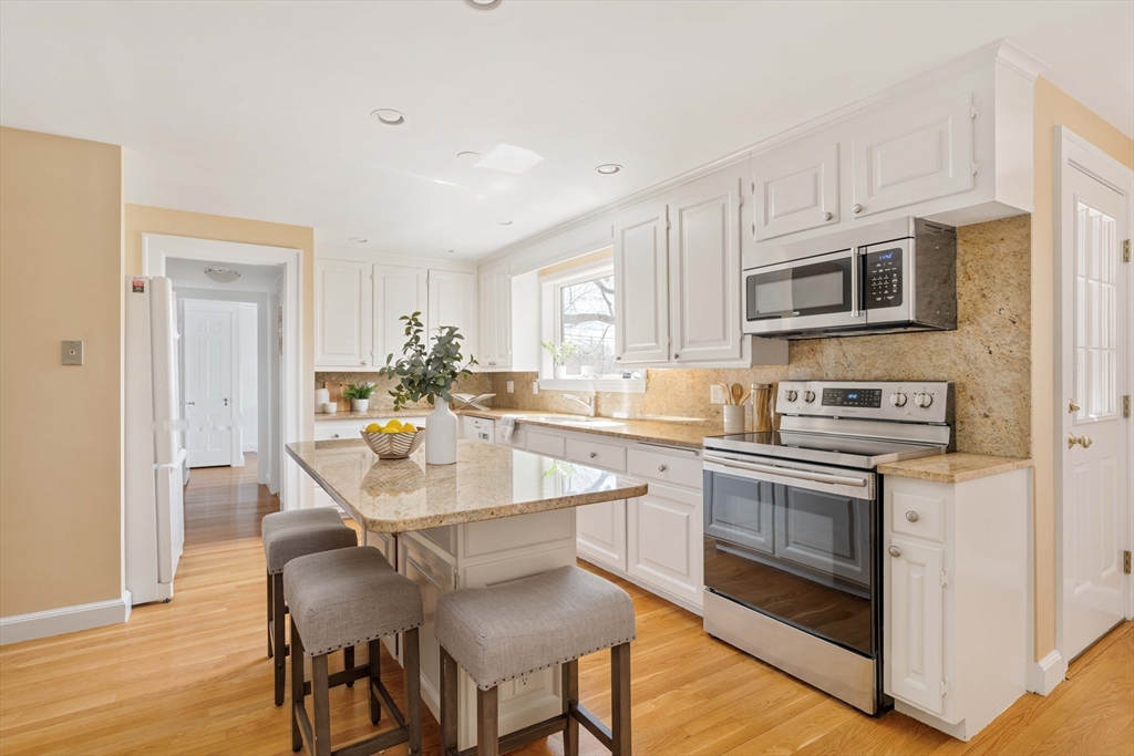 8 Littlefield Road Newton, MA 02459 - Photo 8 of 33 a kitchen with stainless steel appliances granite countertop a stove a sink dishwasher a microwave oven and a refrigerator with wooden floor