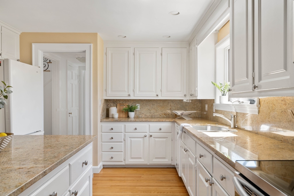 8 Littlefield Road Newton, MA 02459 - Photo 9 of 33 a kitchen with granite countertop white cabinets and white appliances