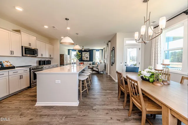a kitchen with a table chairs refrigerator and microwave