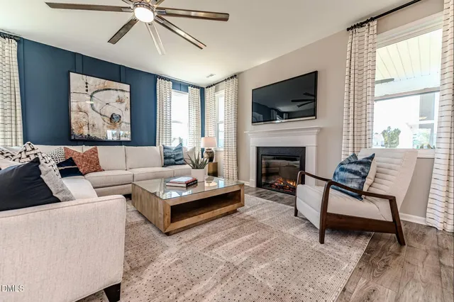 a living room with furniture a flat screen tv and a fireplace