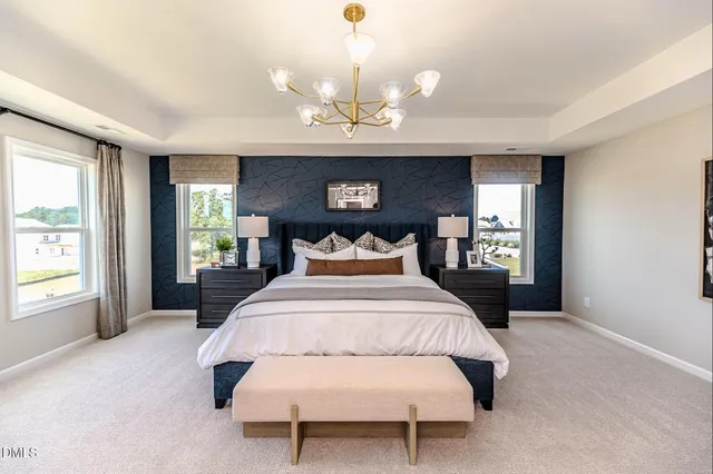 a spacious bedroom with a bed and a chandelier