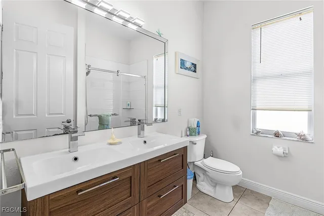 a bathroom with a double vanity sink toilet and a mirror