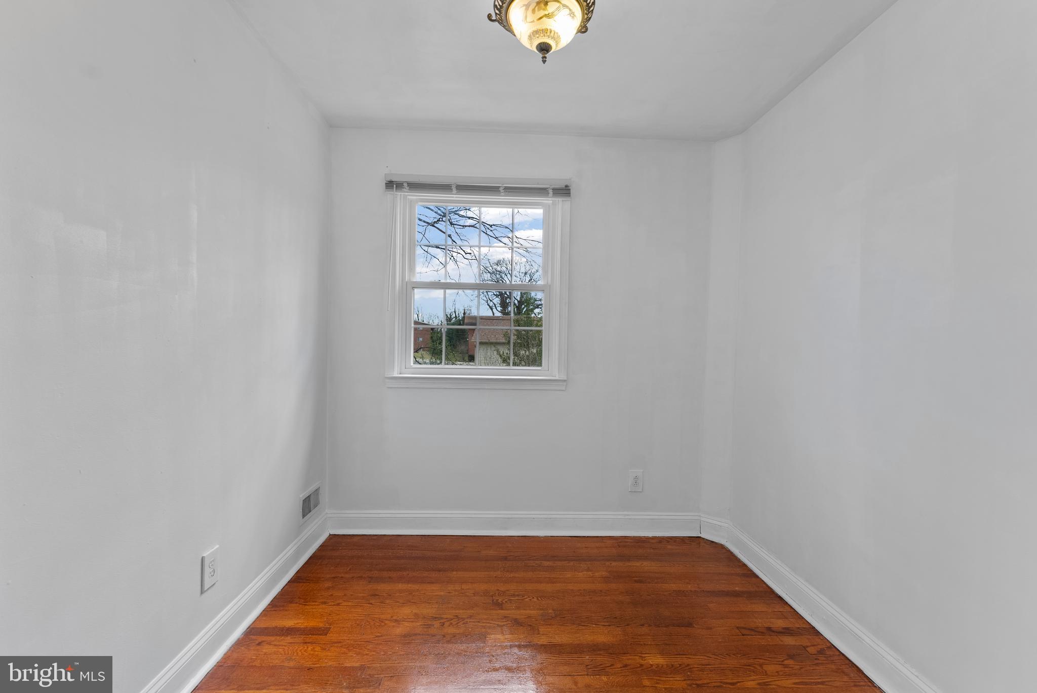 633 Walker Avenue Baltimore, MD 21212 - Photo 10 of 32 an empty room with wooden floor and windows