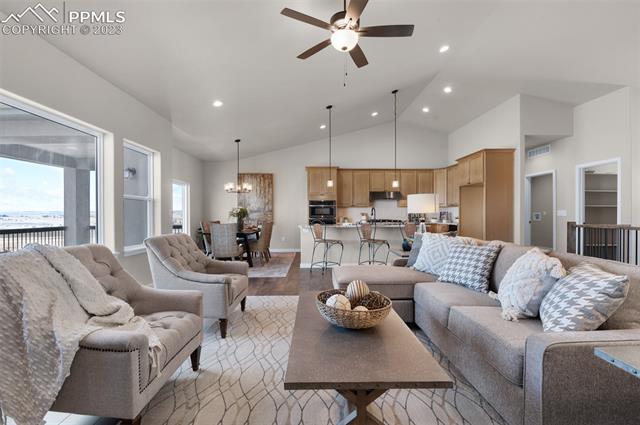 2935 Hoofprint Road Peyton, CO 80831 - Photo 1 of 10 Great Room With Vaulted Ceiling, LVP Flooring, Ceiling Fan, Drop Down Can Lights over Kitchen Island & Can Lights in Ceiling