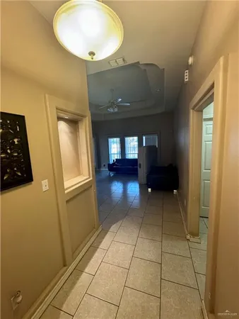 a view of a hallway with wooden floor and a bathroom