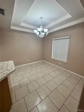 a view of an empty room with a chandelier fan