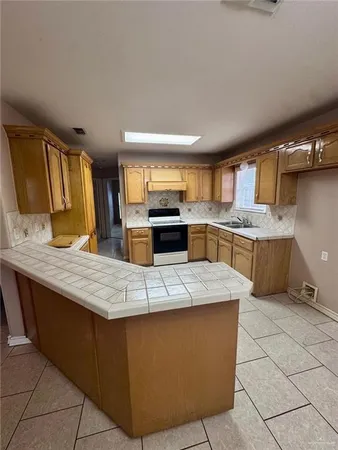 a large kitchen with kitchen island a sink counter top space and cabinets