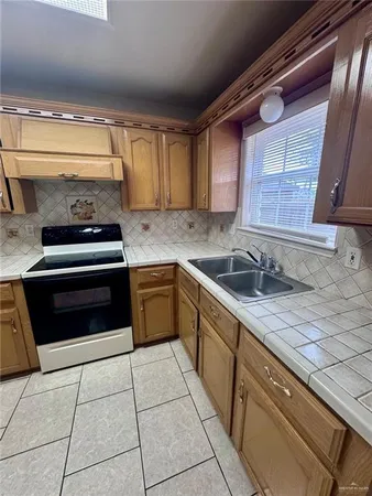 a kitchen with a sink stove and cabinets