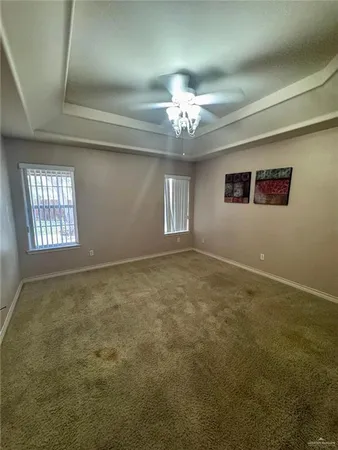 en empty room with windows and ceiling fan