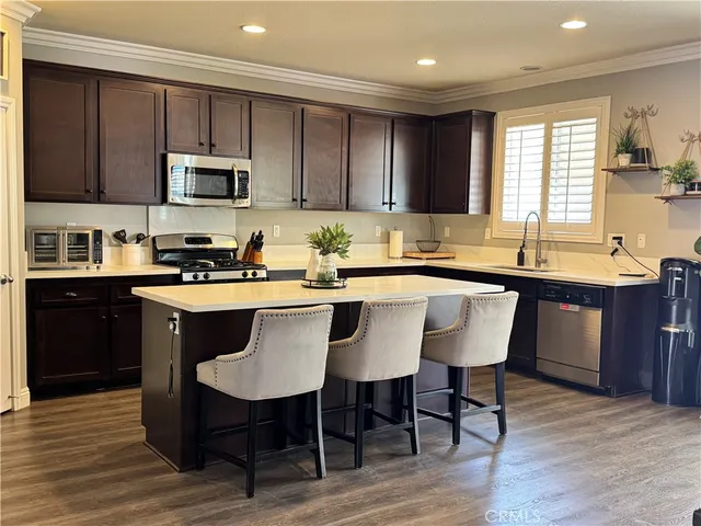 a kitchen with stainless steel appliances granite countertop a table chairs sink refrigerator and microwave