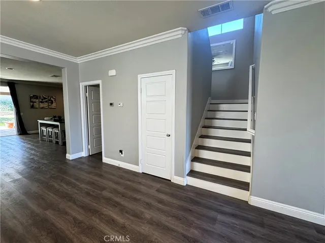 a view of a livingroom with wooden floor and stairs