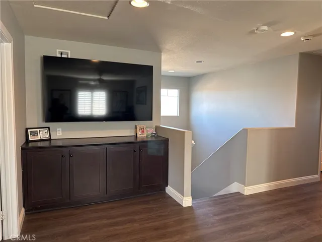 a living room with wooden floor and flat screen tv