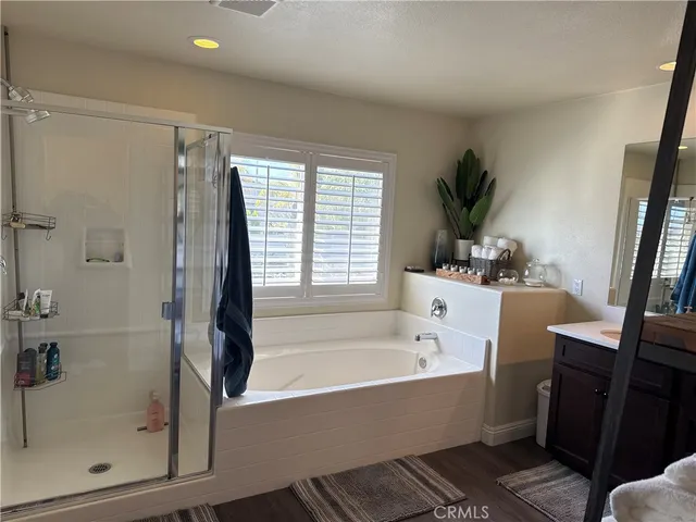 a bathroom with a bathtub shower sink vanity and toilet