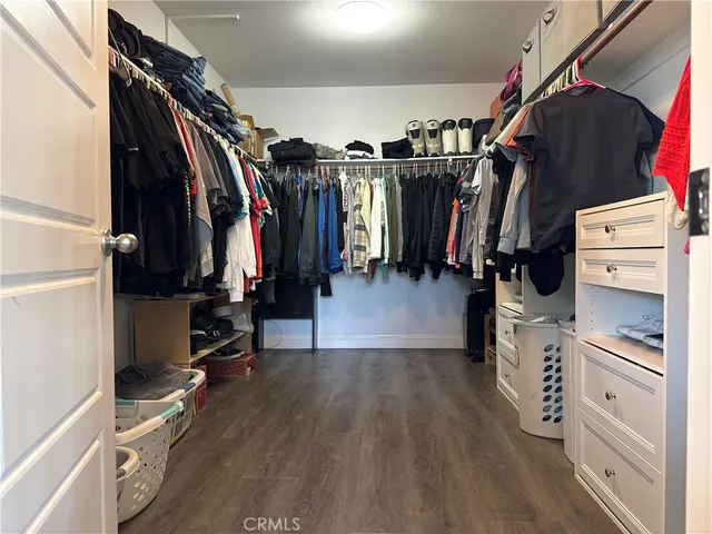 a view of walk in closet with clothes and shoes