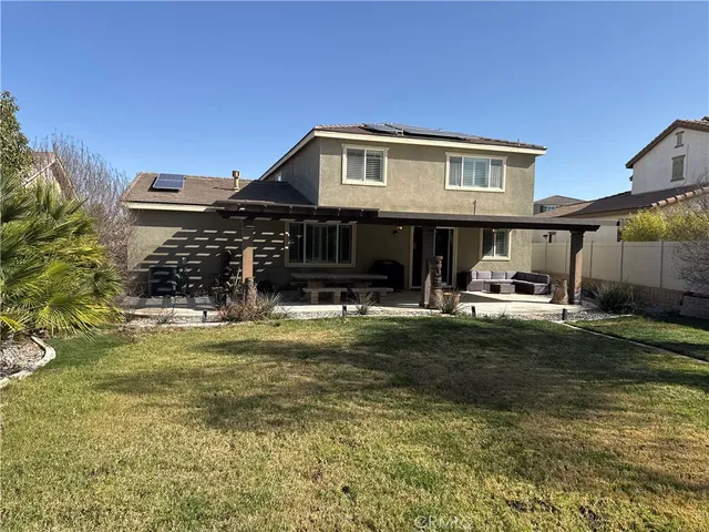 a view of a house with backyard porch and sitting area