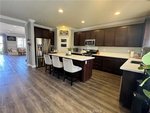 a large kitchen with a large counter top furniture appliances and wooden floor