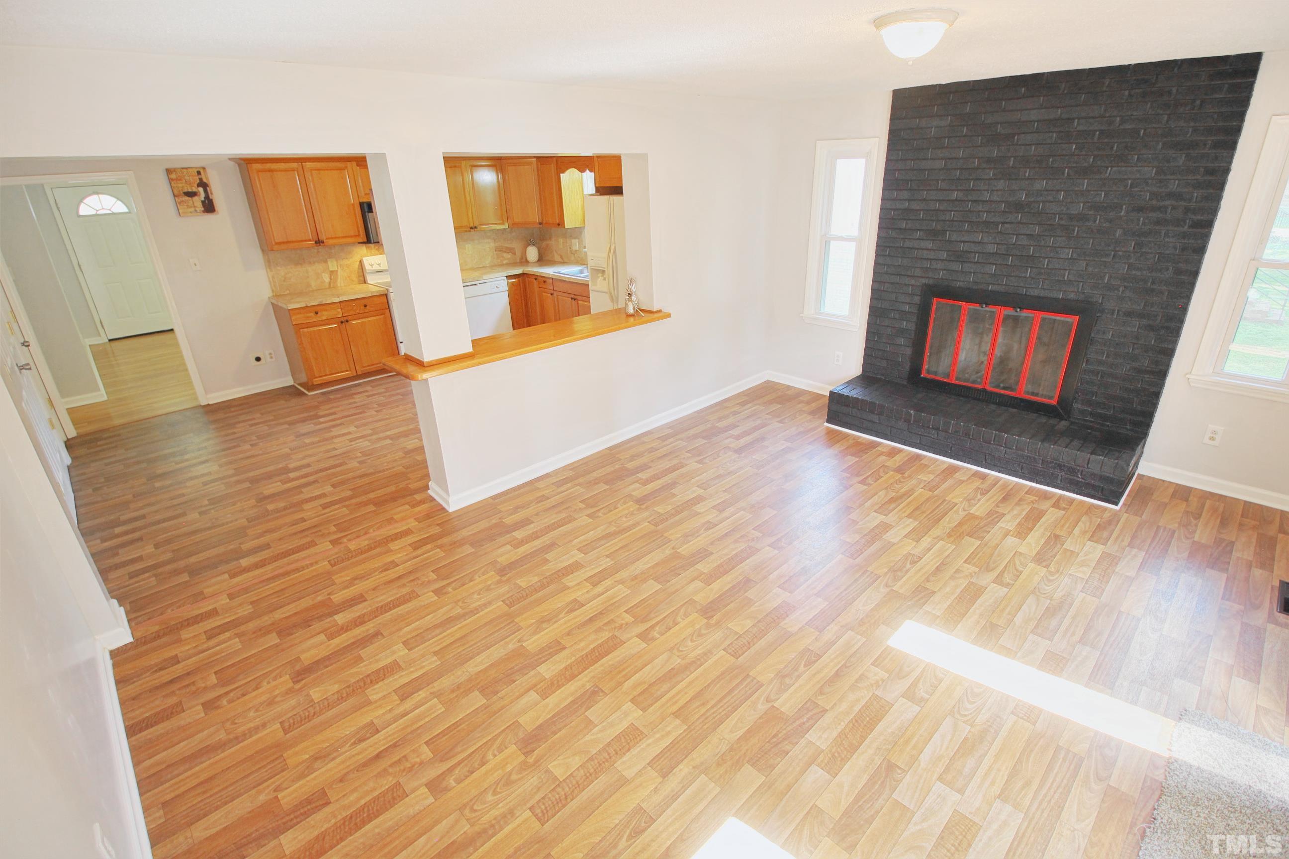 548 Dacian Road Raleigh, NC 27610 - Photo 11 of 16 a view of an empty room with wooden floor and a fireplace