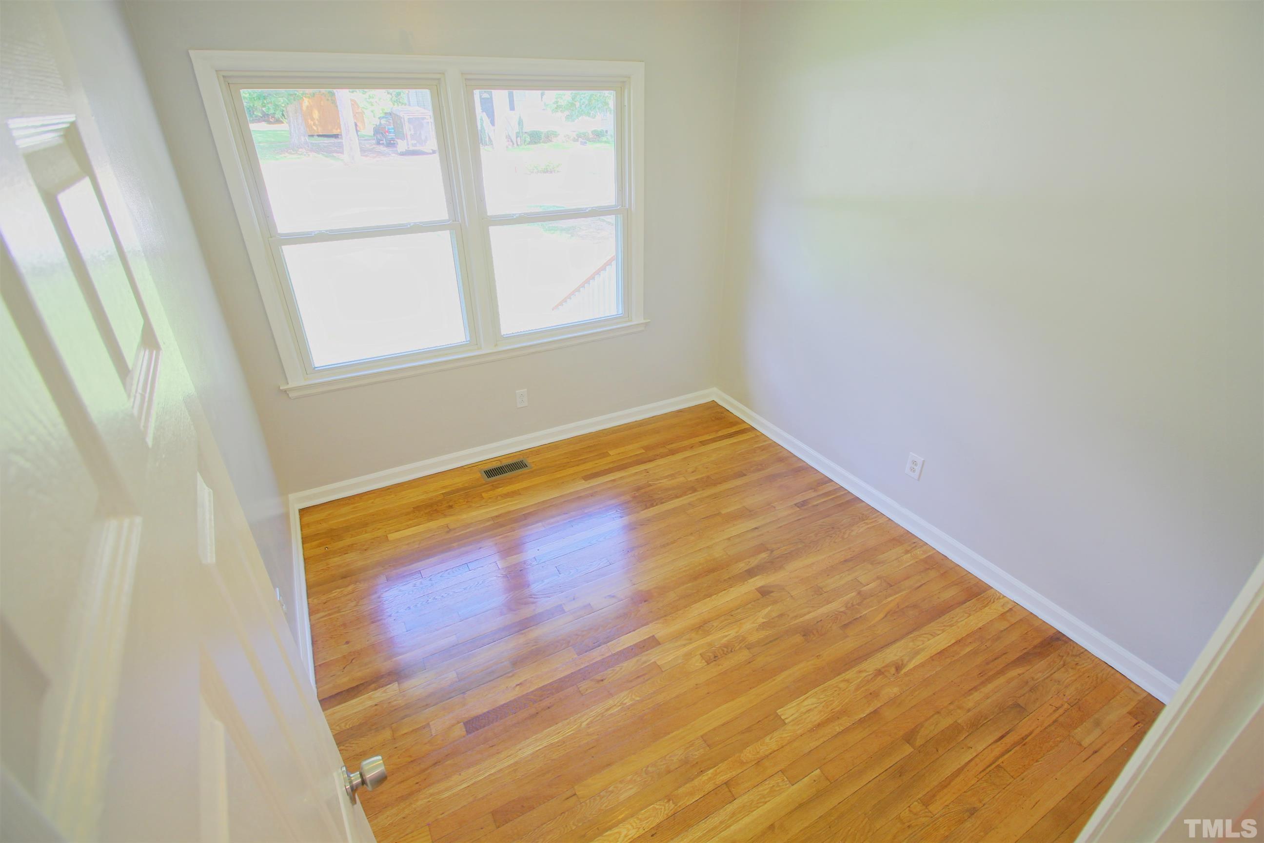 548 Dacian Road Raleigh, NC 27610 - Photo 4 of 16 a view of empty room with wooden floor and fan