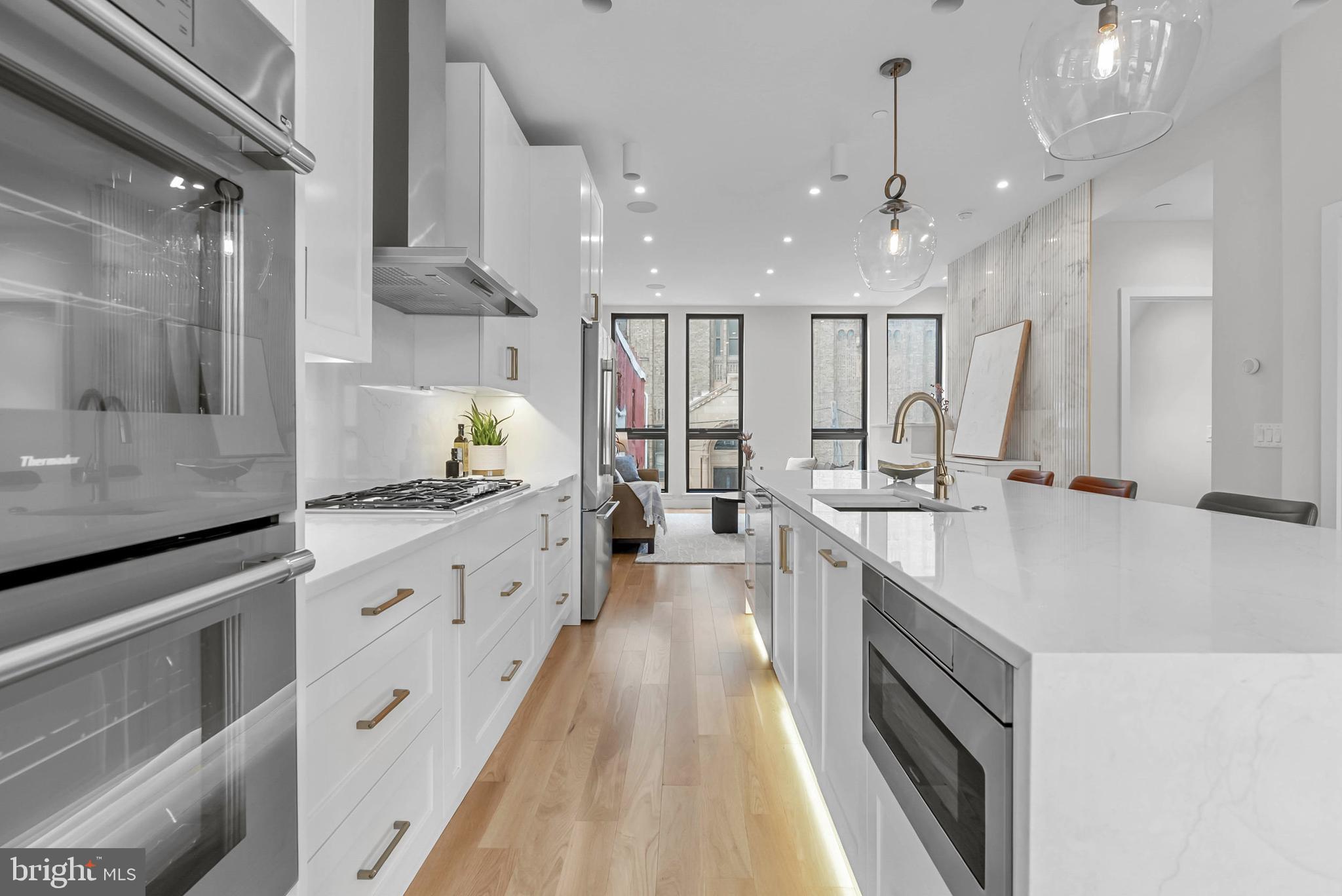 1100 Webster Street, Unit 4 Philadelphia, PA 19147 - Photo 5 of 53 a large kitchen with kitchen island a large counter space a sink stainless steel appliances and cabinets