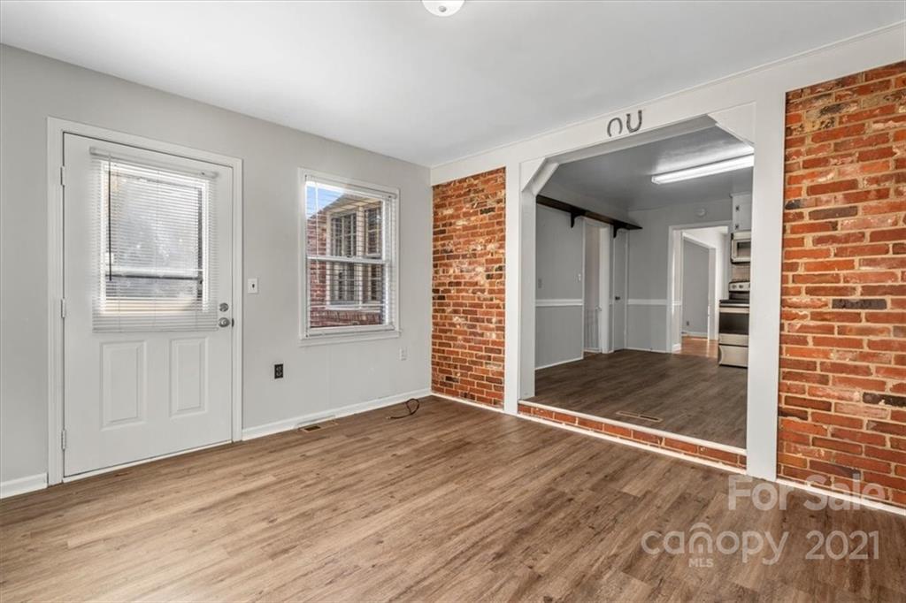 4919 Seacroft Road Charlotte, NC 28210 - Photo 11 of 25 an empty room with wooden floor and windows