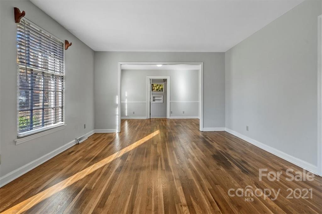 4919 Seacroft Road Charlotte, NC 28210 - Photo 4 of 25 a view of empty room with wooden floor and fan