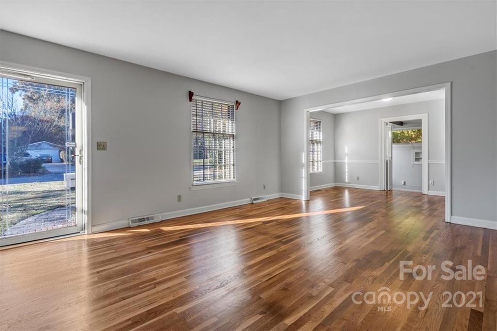 4919 Seacroft Road Charlotte, NC 28210 - Photo 5 of 25 an empty room with wooden floor and windows