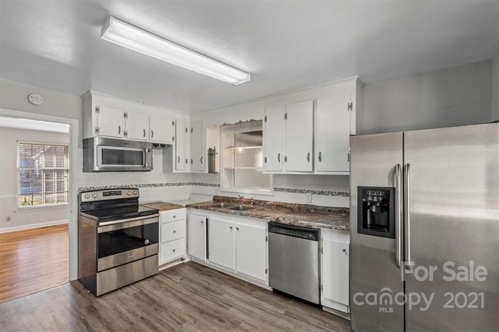 4919 Seacroft Road Charlotte, NC 28210 - Photo 9 of 25 a kitchen with cabinets stainless steel appliances and wooden floor