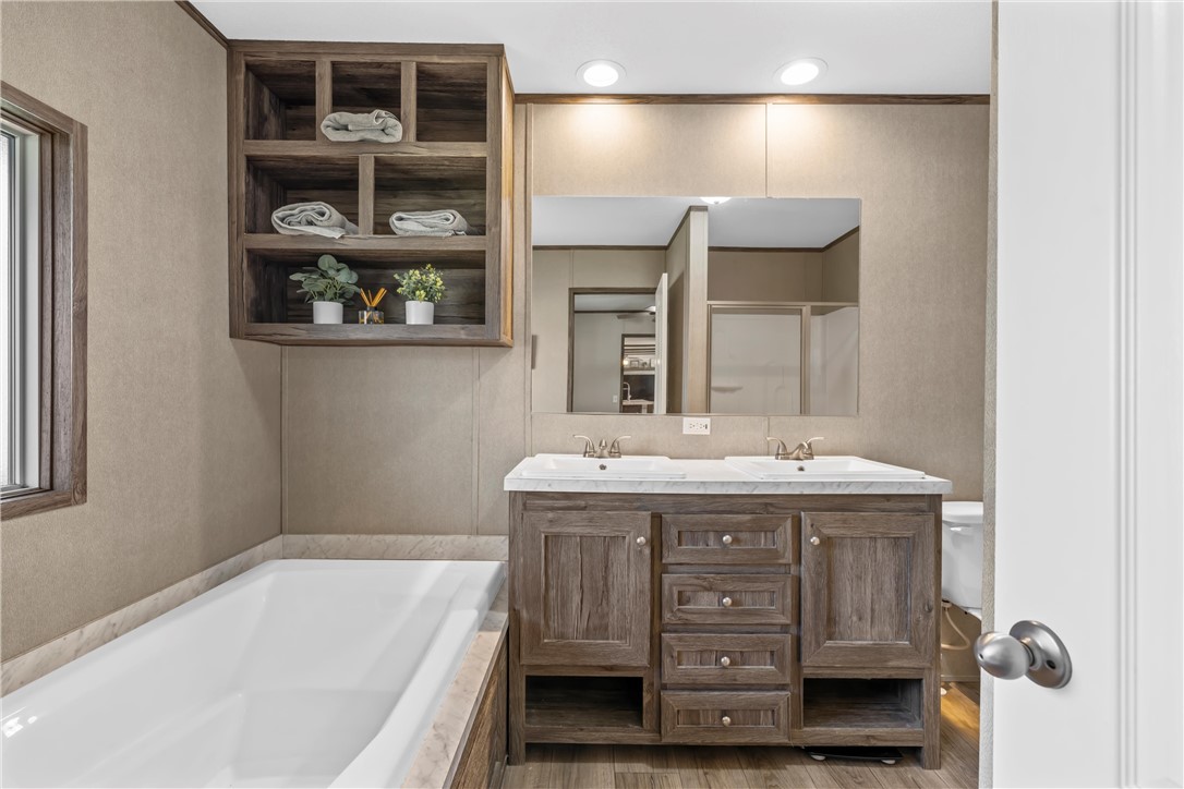 5481 Tokio Road West, TX 76691 - Photo 12 of 23 a bathroom with a granite countertop sink a vanity and bathtub