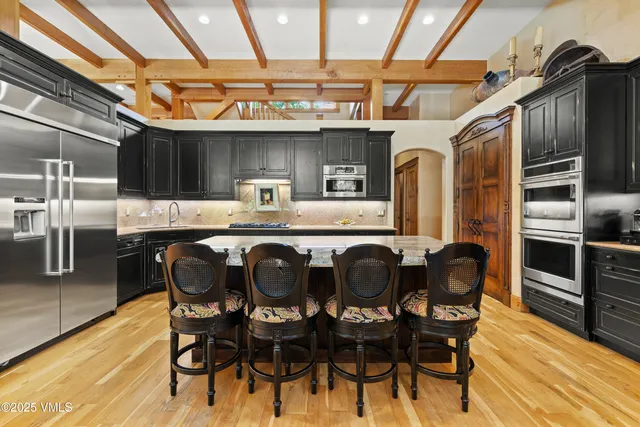 a kitchen with stainless steel appliances granite countertop a stove a sink dishwasher and cabinets with wooden floor