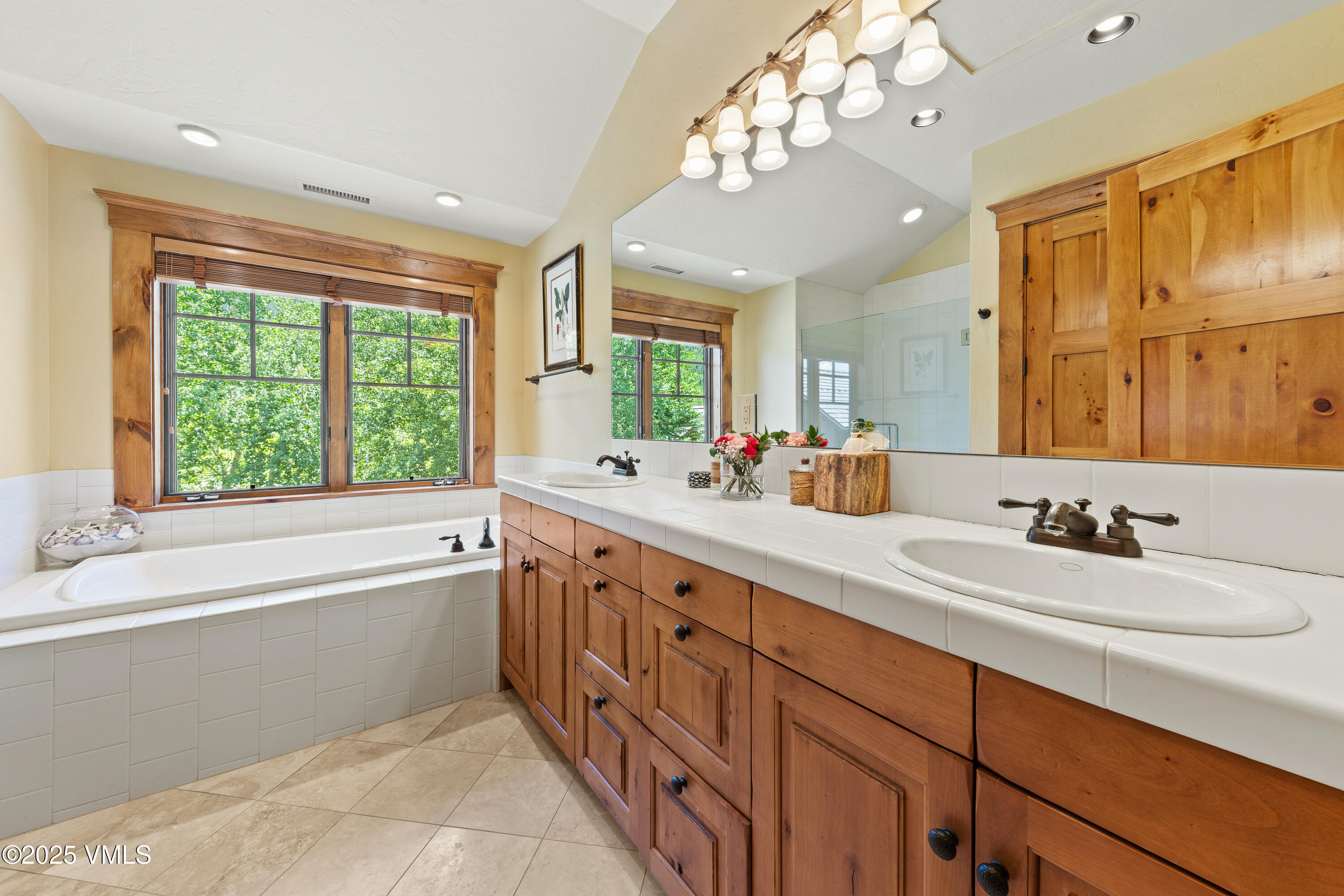 33 Grey Hawk Lane Edwards, CO 81632 - Photo 45 of 78 a bathroom with double vanity sinks a large mirror and a bathtub