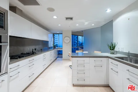 a kitchen with stainless steel appliances granite countertop a sink and a refrigerator