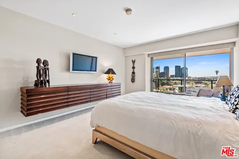 a bedroom with a bed and a flat screen television