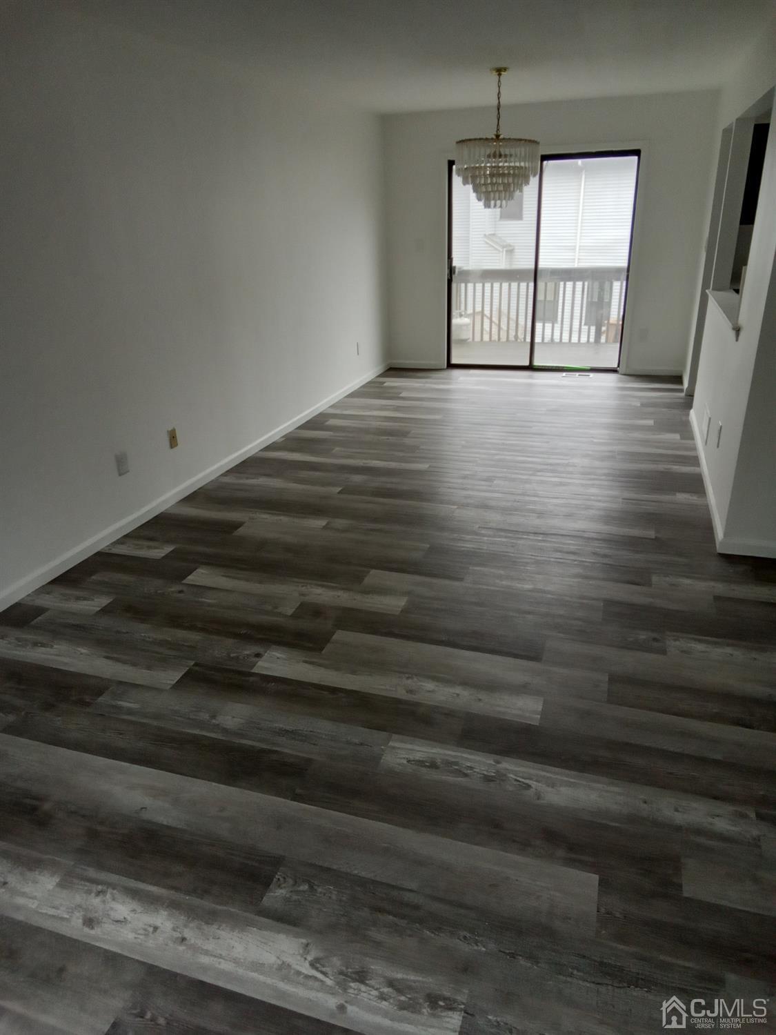 1403 Timber Oaks Road Edison, NJ 08820 - Photo 3 of 6 a view of an empty room with wooden floor and fan