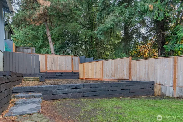 a view of a backyard with wooden fence