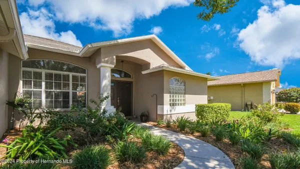 a view of a house with brick walls and potted plants