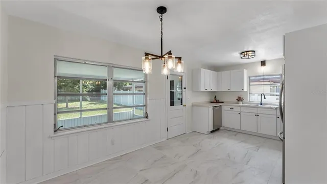 a kitchen with cabinets appliances a sink and a window