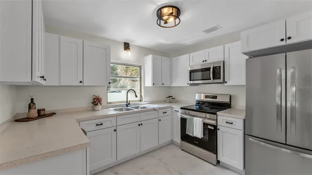 a kitchen with white cabinets a sink and a stove