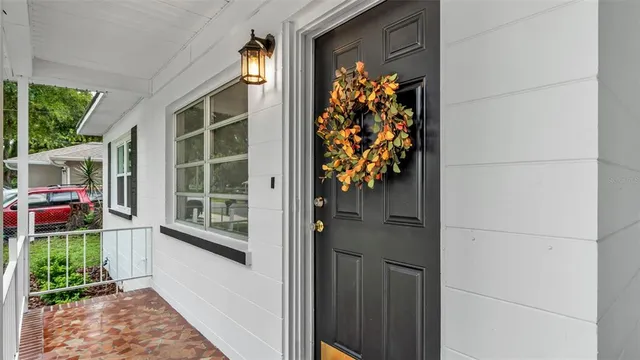 front view of a house with a large window and wooden fence