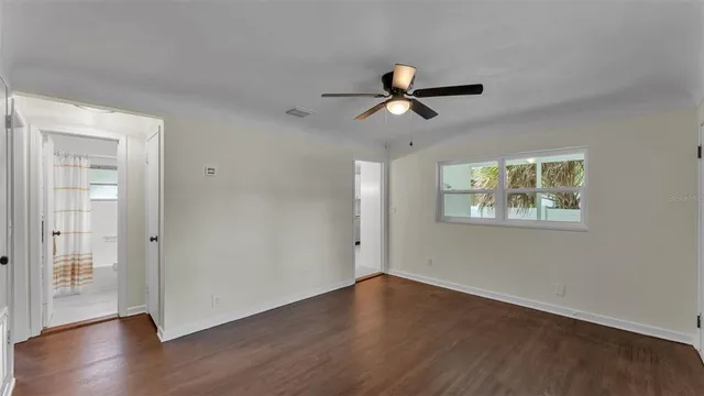 a view of room with hardwood floor and a ceiling fan