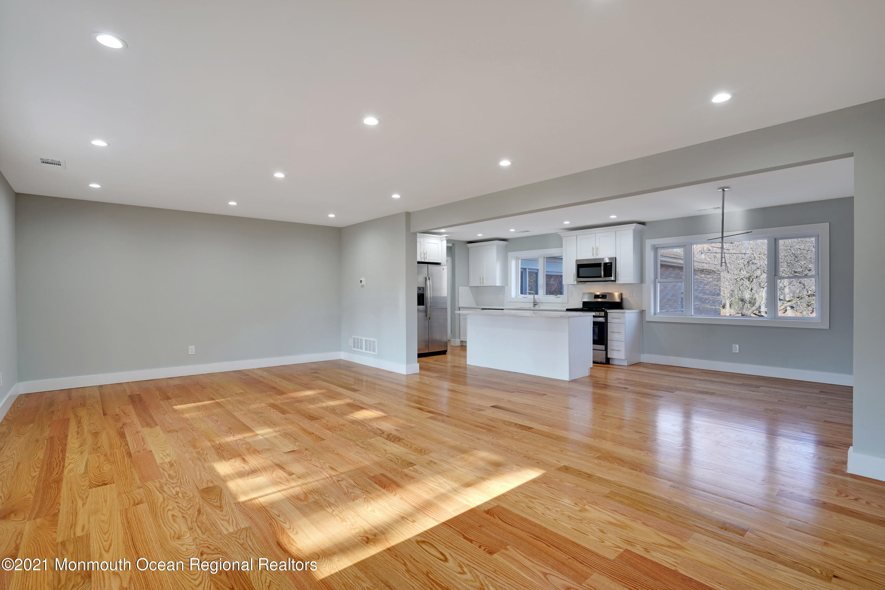 1155 Crim Road Bridgewater, NJ 08807 - Photo 6 of 29 a view of an empty room with wooden floor and a kitchen